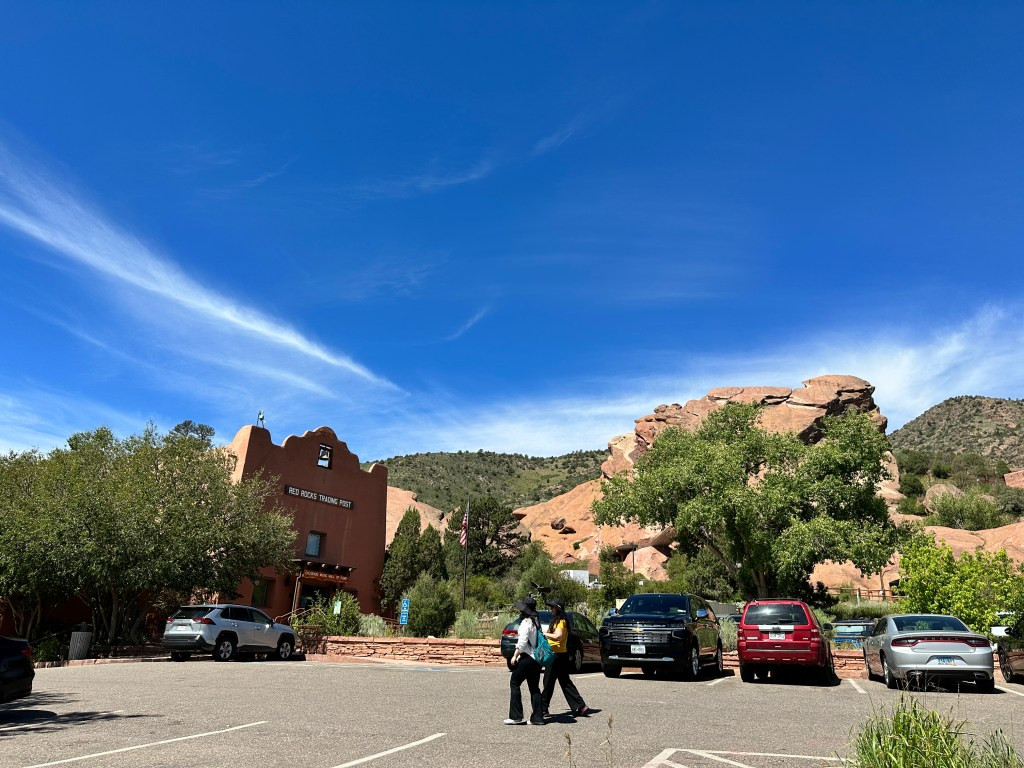 The parking area directly in front of the historic Trading Post building, marking the trailhead access.