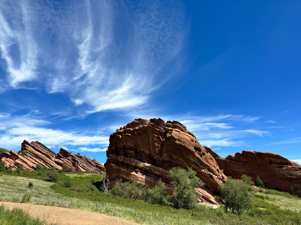 Another view of the Trading Post Trail with hikers enjoying the path and the dramatic red rock scenery.