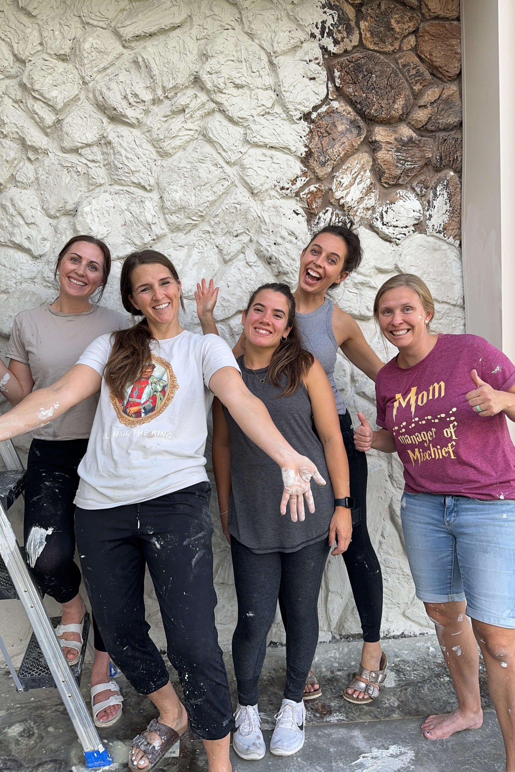 A group of friends helping to apply mortar to the exterior rock siding.