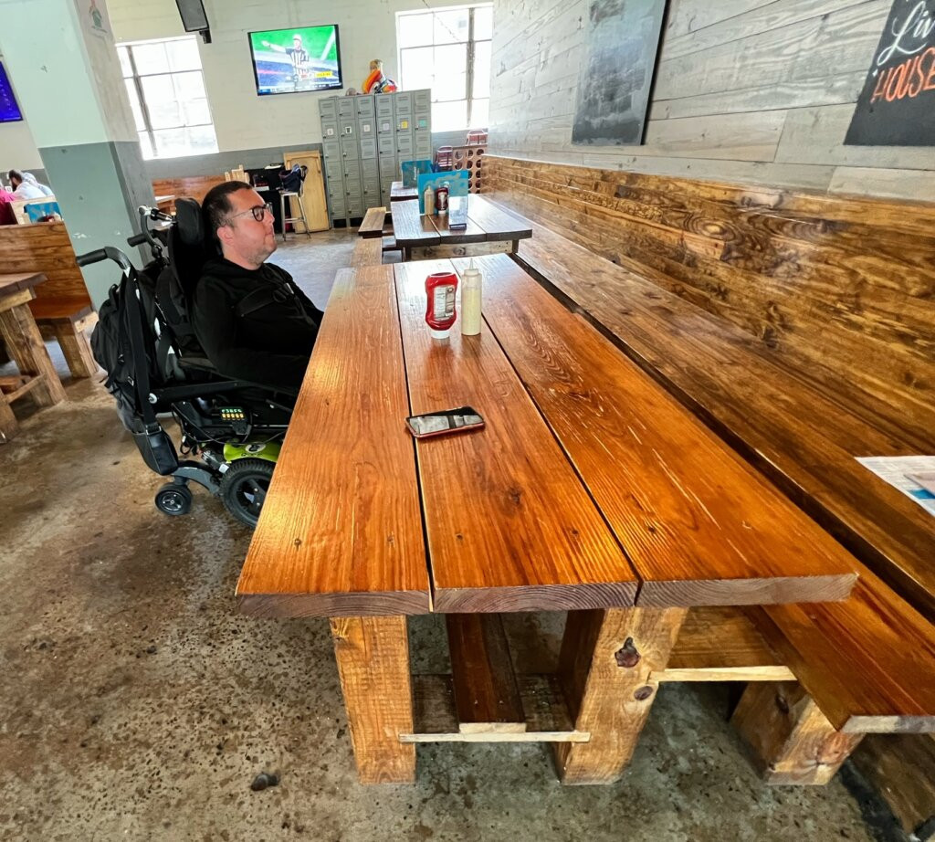 Wheelchair user enjoying a sausage sampler at Fassler Hall in Little Rock, Arkansas