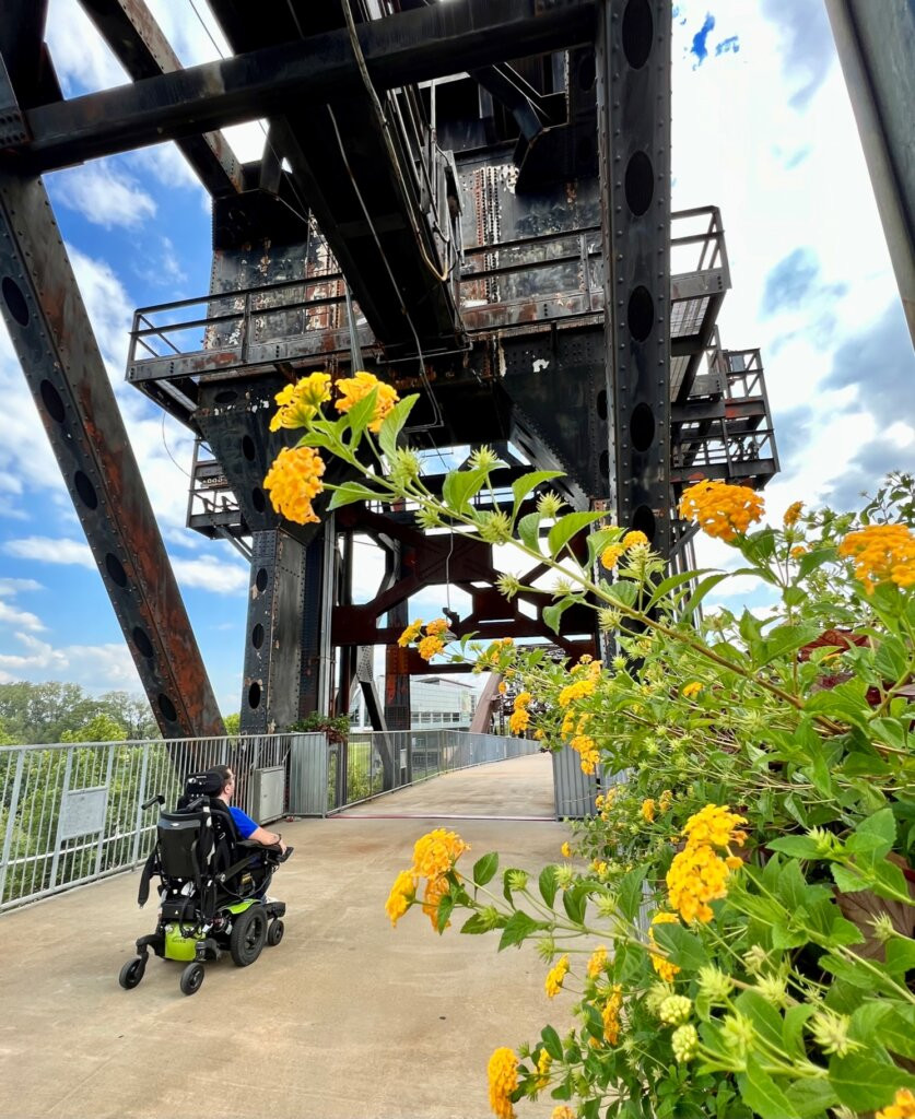 Wheelchair user smiling in front of the Clinton Presidential Center in Little Rock, Arkansas