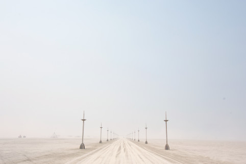 Dusty skies over Black Rock City, Nevada, during Burning Man setup, hinting at the dry desert environment that quickly resolved the bug infestation.