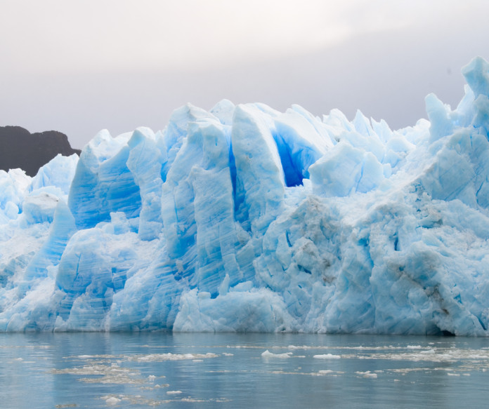 A stunning glacier landscape under a cloudy sky, showcasing the vastness and beauty of glacial ice.