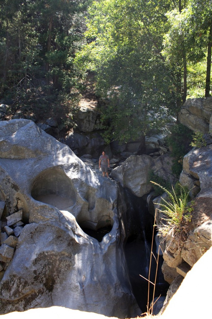 Person standing above Heart Rock Waterfall to show the size of the heart rock