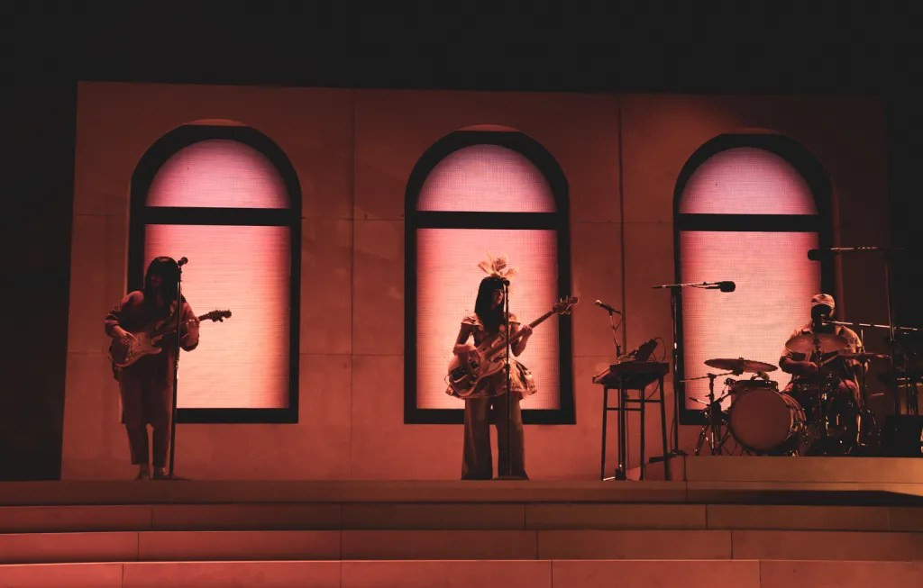 Khruangbin's stage setup at Red Rocks, featuring arched windows and minimalist design enhancing their performance.