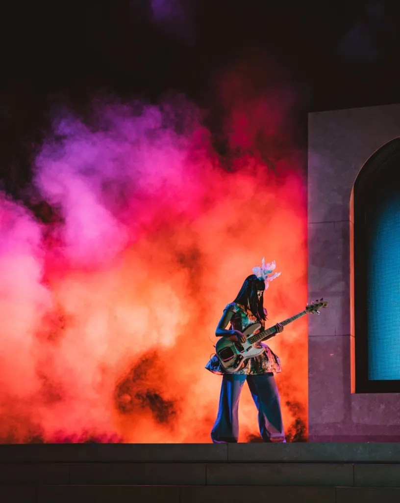 Khruangbin performing under the vast Red Rocks sky as night descends, creating a magical atmosphere.