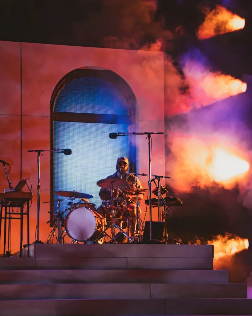 Khruangbin guitarist Mark Speer playing under the Red Rocks lights, his silhouette adding to the mystique.