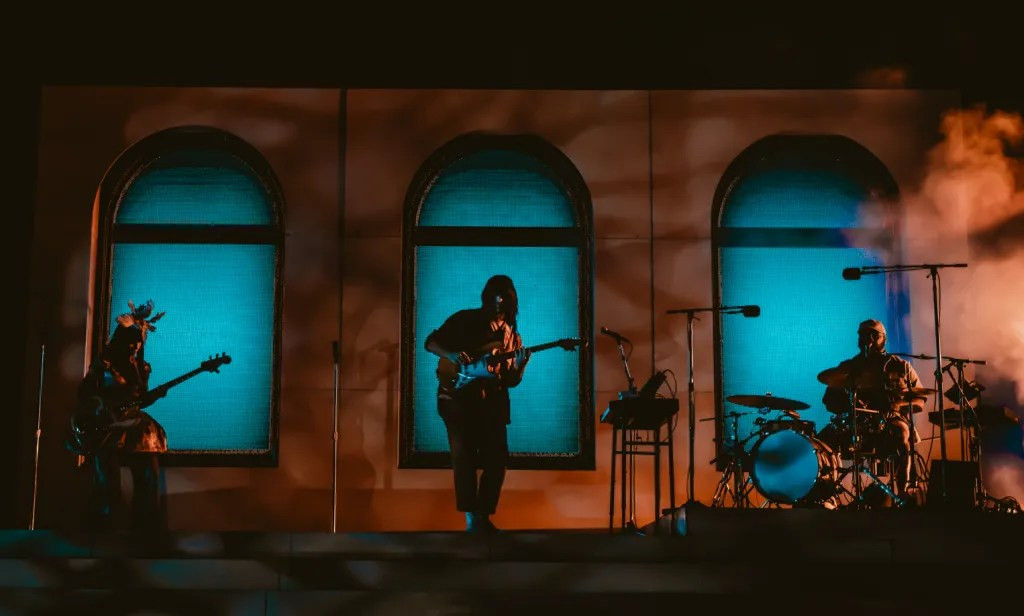 Wide angle shot of Khruangbin performing on the Red Rocks stage, showcasing the minimalist yet impactful production.