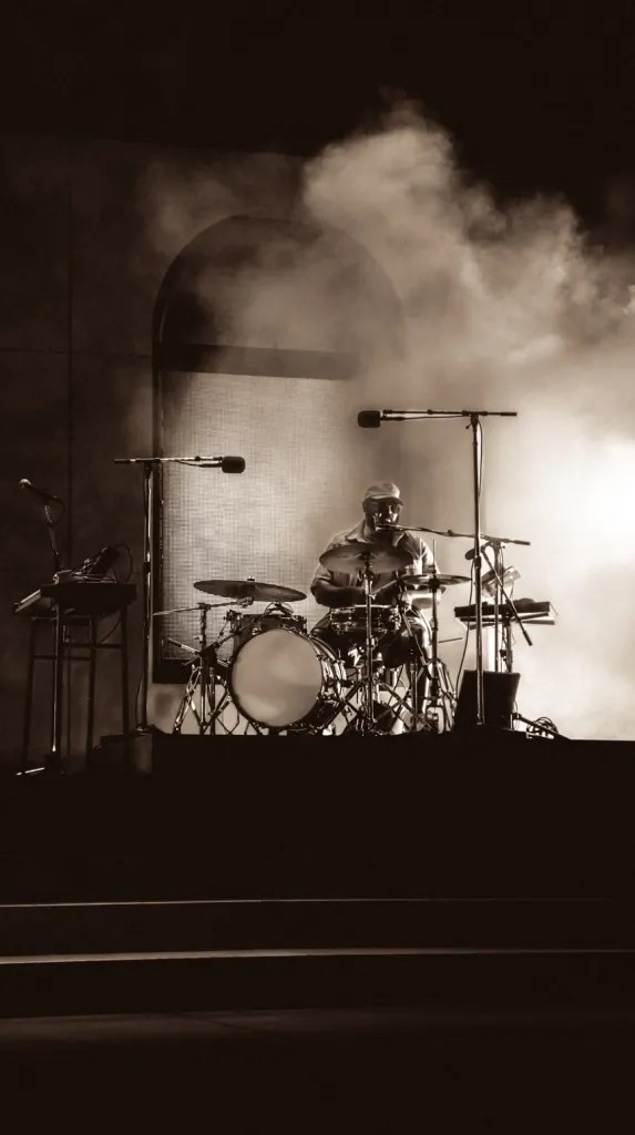 Khruangbin's stage presence against the backdrop of Red Rocks, a perfect synergy of music and nature.