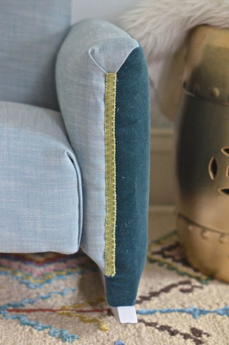 Armrest of the rocking chair showing color-blocked fabric and gimp trim covering the staples.