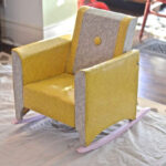 Dated kids rocking chair before reupholstering, showing worn fabric and wooden frame.