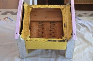 Close-up of staple remover tool being used to remove old staples from the rocking chair frame.