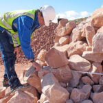 Engineer inspecting large rip rap rocks for erosion control project