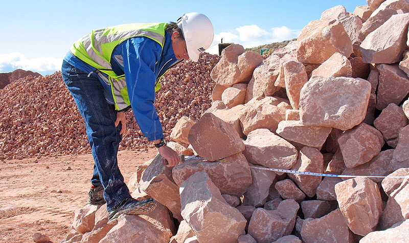 Engineer inspecting large rip rap rocks for erosion control project