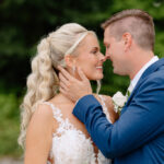 Lexi and Matt share a kiss amidst lush greenery at their Rock Island Lake Club wedding