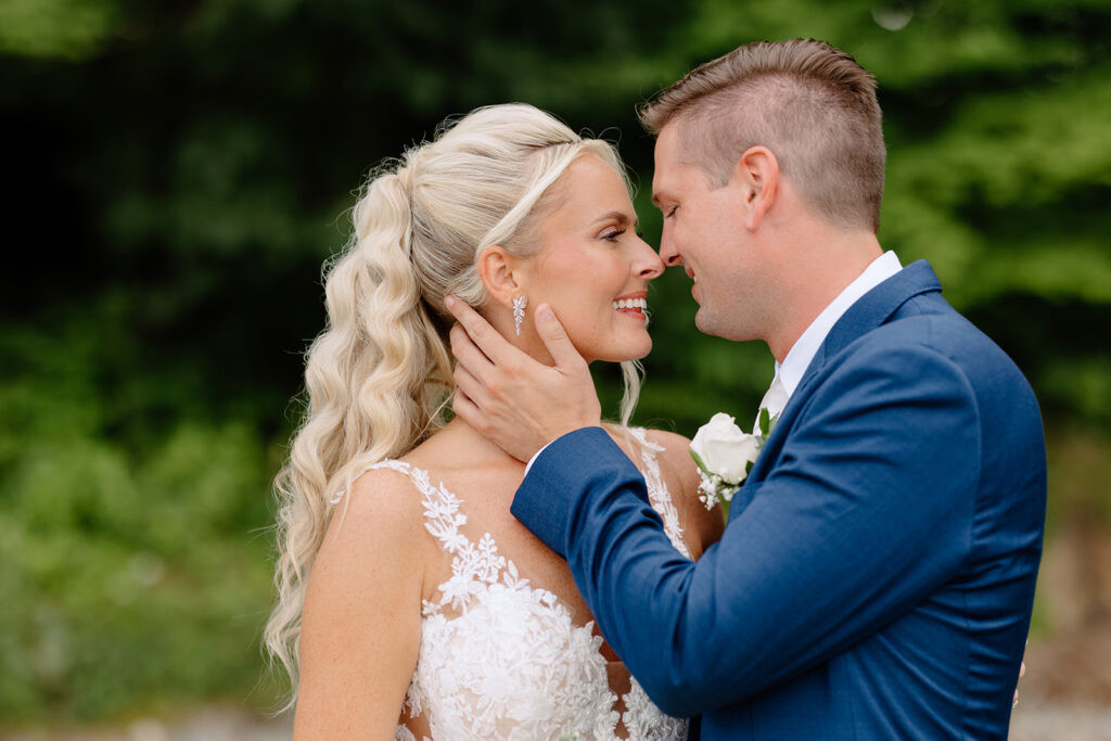 Lexi and Matt share a kiss amidst lush greenery at their Rock Island Lake Club wedding