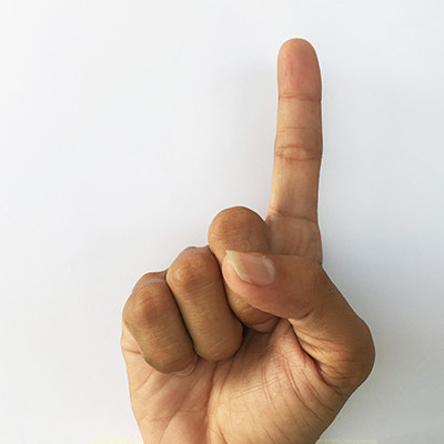 Hand gesture with index finger raised, signifying &quot;number one&quot; but offensive in some cultures.