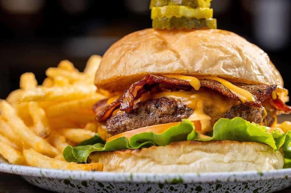 Close up of a juicy burger from Old Town Kitchen, a must-try menu item at this Rock Hill eatery