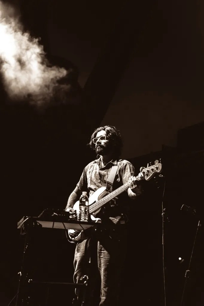 Peter Cat Recording Co. guitarist playing under vibrant stage lighting at Red Rocks Amphitheatre.