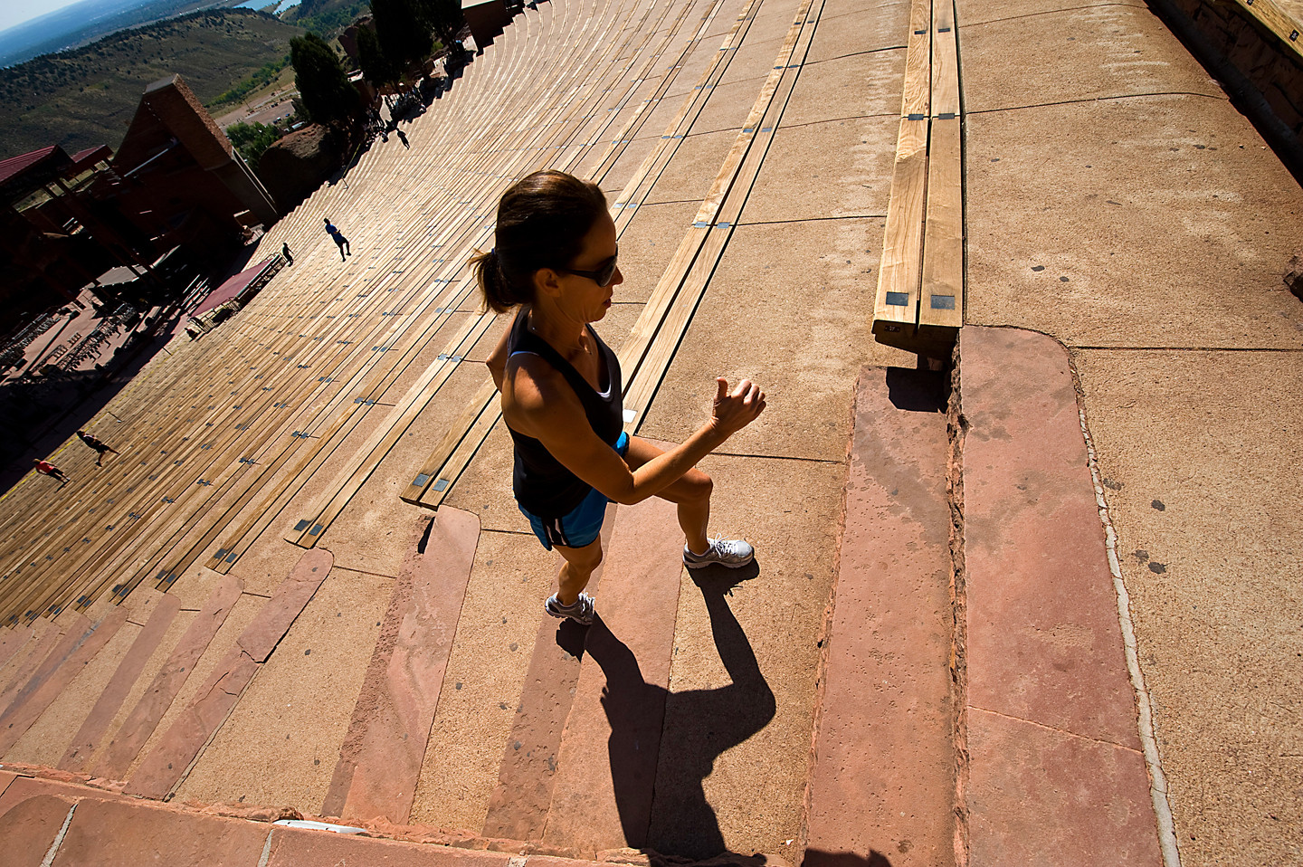 Woman Exercising on Red Rocks Stairs: Shows the amphitheatre steps being used for fitness, highlighting the park's dual purpose as a recreation and event space.