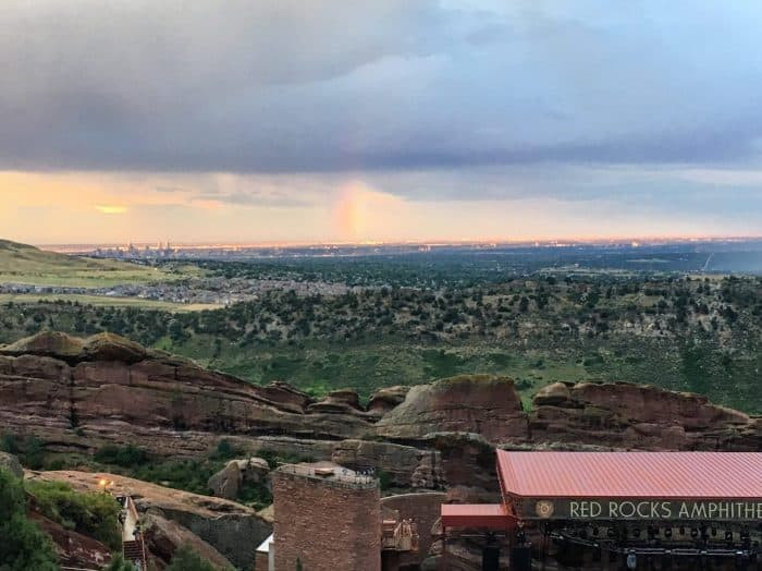 Fans enjoying a concert at Red Rocks Amphitheatre under a colorful sky