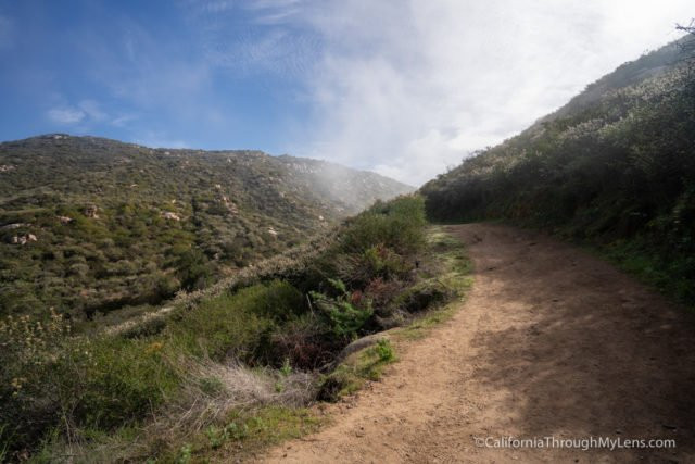 Hiking towards the summit of Mt. Woodson, radio towers visible in the distance, a landmark on the Potato Chip Rock trail in Poway.