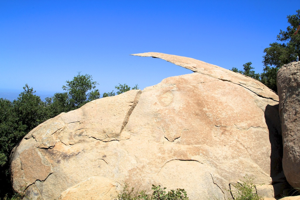 Adventurous hiker standing confidently on Potato Chip Rock, a thin, wafer-like rock formation in Poway, California, showcasing the thrill of the hike.