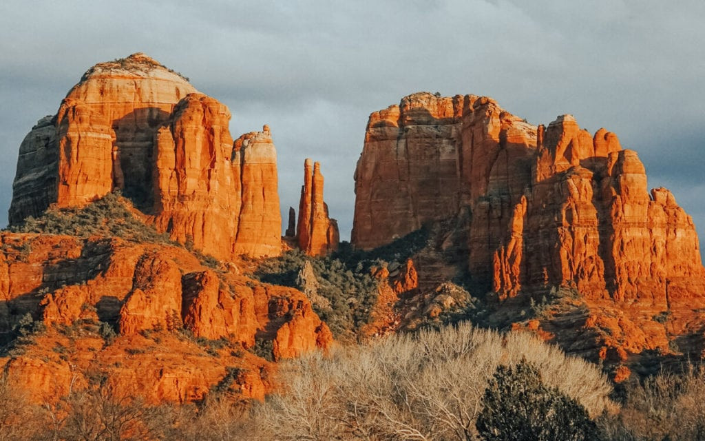 The fiery sunset paints the sky and Cathedral Rock in vibrant hues as seen from Red Rock Crossing in Sedona, AZ.