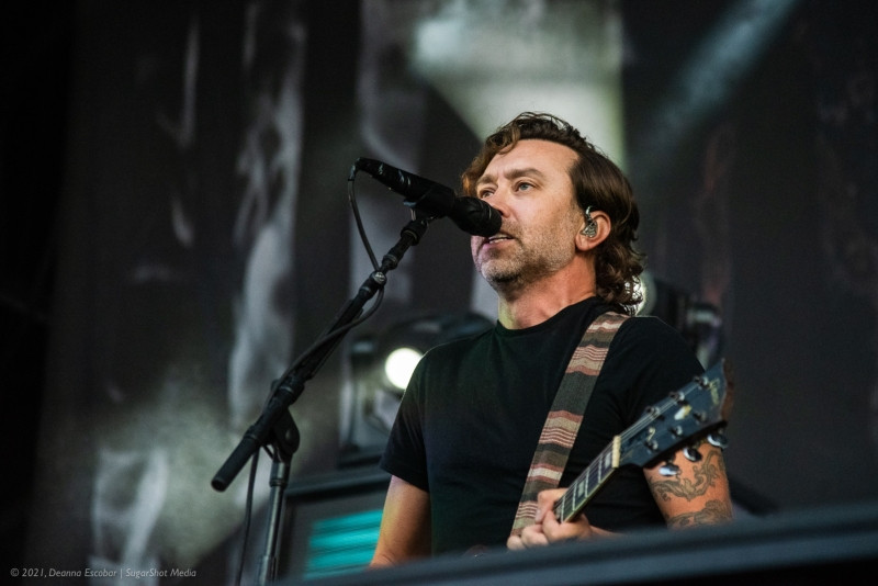 Tim McIlrath of Rise Against singing at Blue Ridge Rock Festival Day 2. The Rise Against vocalist is passionately singing into the microphone on stage.