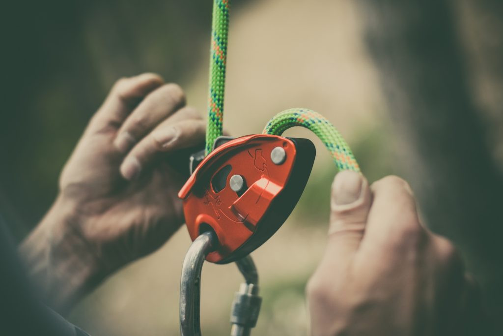 Belay device for controlled rope management in rock climbing