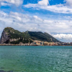 Rock of Gibraltar as seen from afar, highlighting its coastal location.