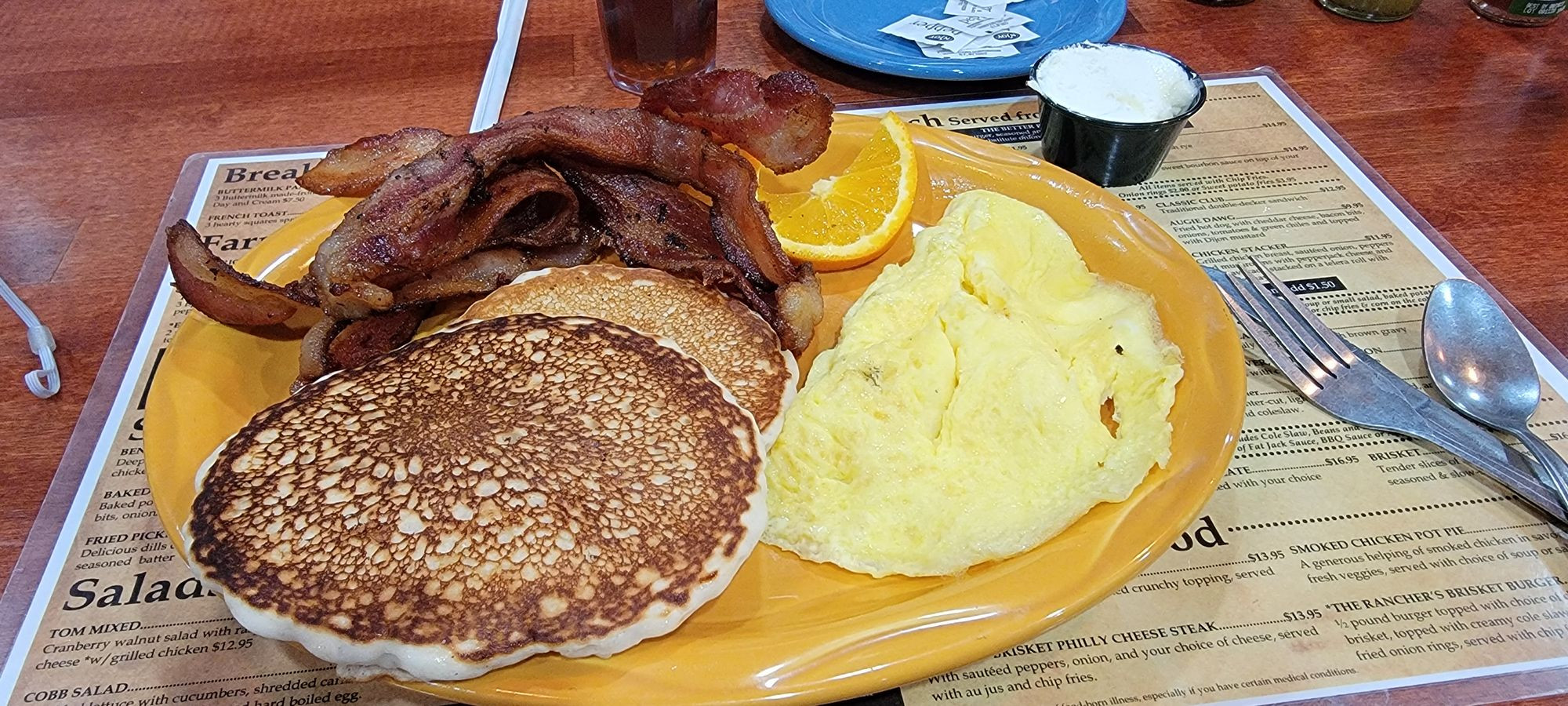 A delicious breakfast spread at Rock Springs Cafe featuring scrambled eggs, pancakes, and crispy bacon, showcasing their classic morning fare.