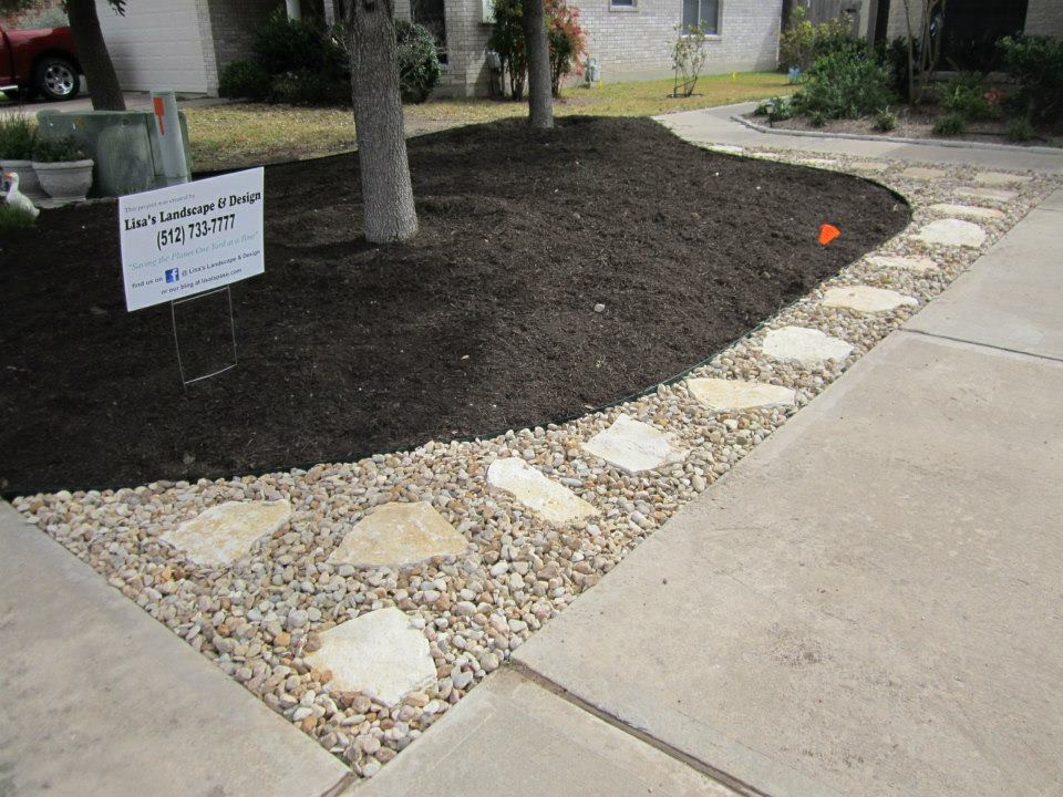 River rock landscape bed with stepping stones and surrounding plants, showcasing a harmonious blend of hardscape and softscape elements.