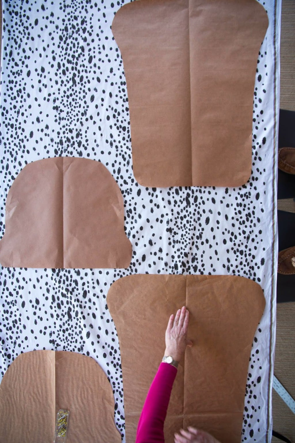 Fabric pieces being cut for DIY rocking chair cushions, showing fabric being prepared for sewing