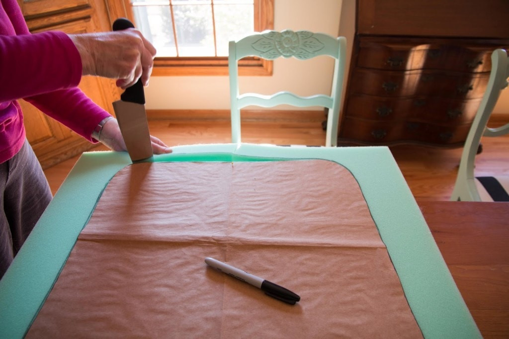 Close-up view of cutting foam for rocking chair cushions, showcasing the use of a knife for shaping the foam