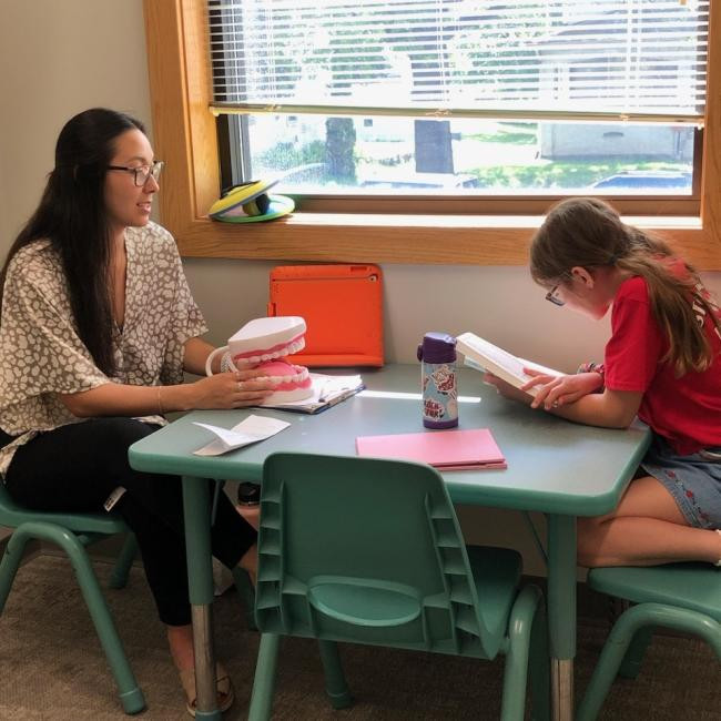 Researcher working with a young client at the Augustana College speech and hearing center