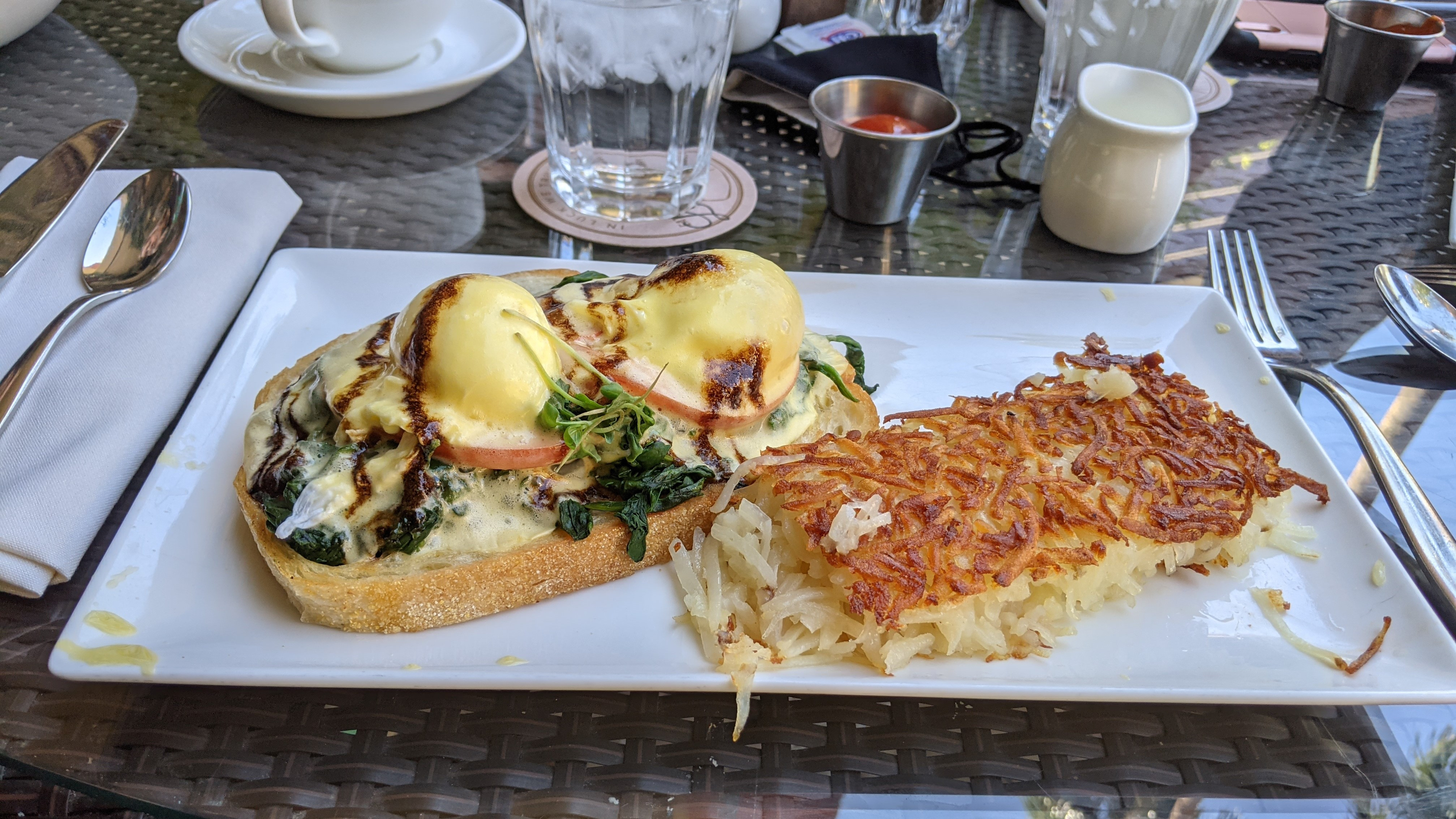 Eggs benedict on sourdough bread and hash browns