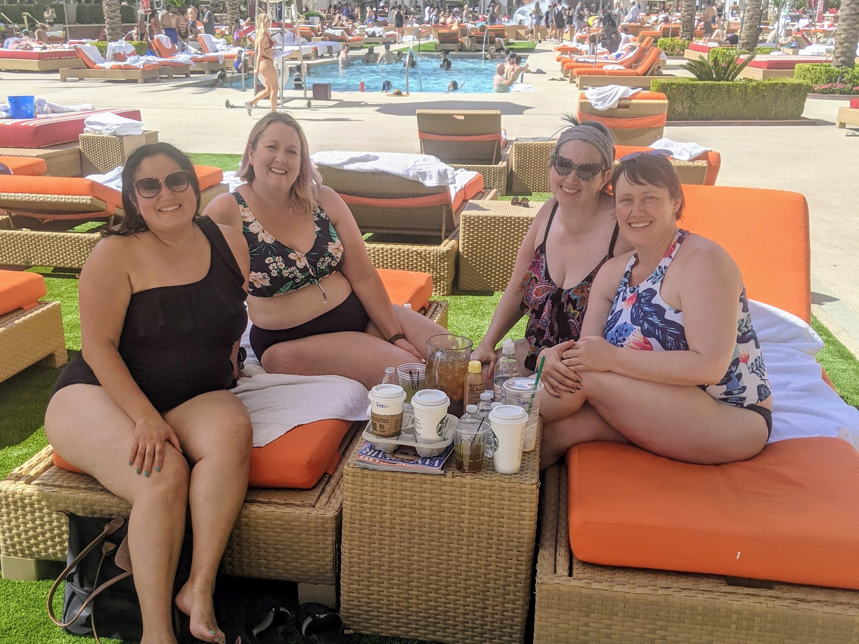 4 women sitting on pool loungers by the pool in Vegas