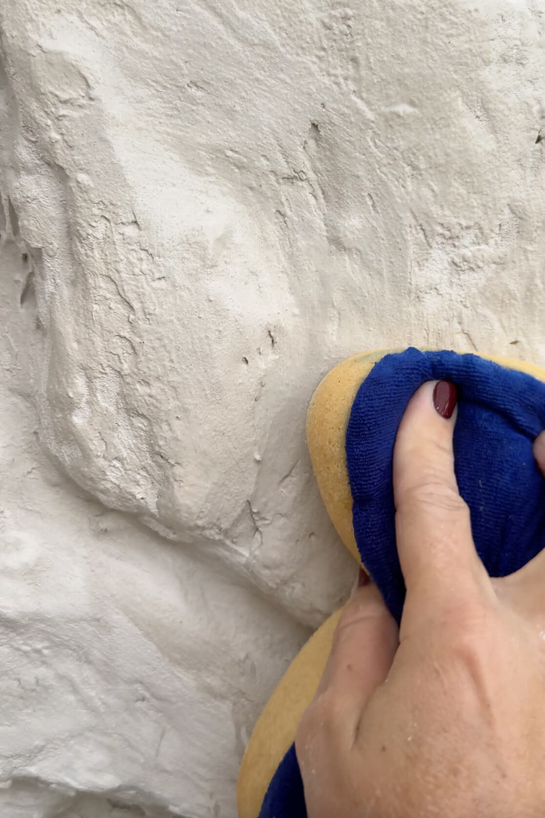 Close-up of the sponging technique to create a smooth mortar finish on rock siding.