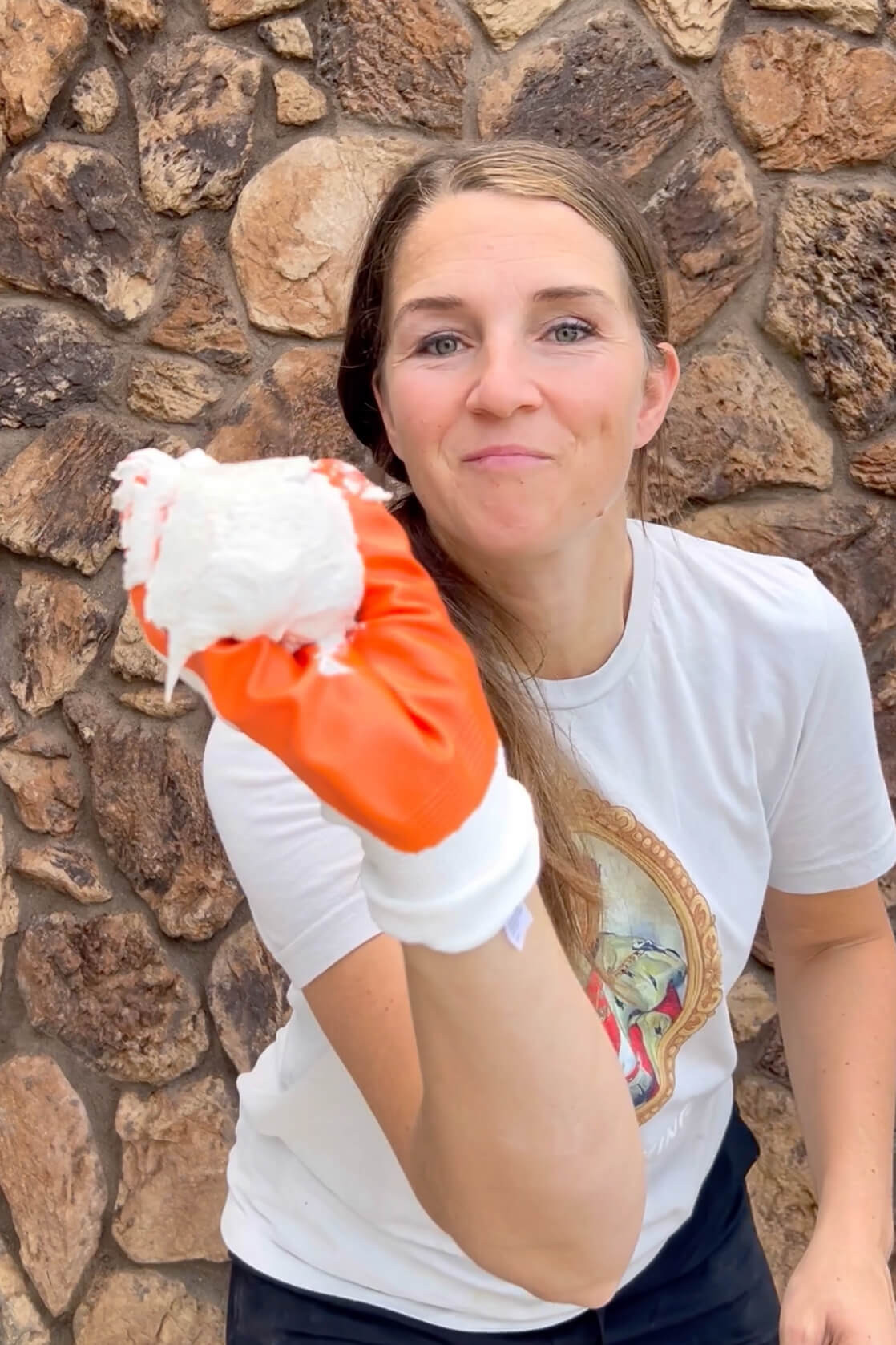 Applying mortar by hand to the rock siding to create a smoother surface.