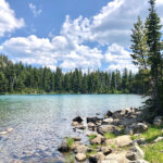 Shoe Lake trail in Goat Rocks Wilderness presenting a serene alpine lake surrounded by forests and peaks