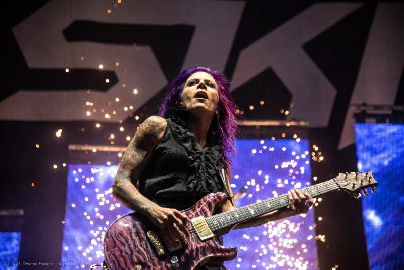 Korey Cooper of Skillet playing guitar at Blue Ridge Rock Festival Day 1. The guitarist is energetically performing on stage, illuminated by concert lights.