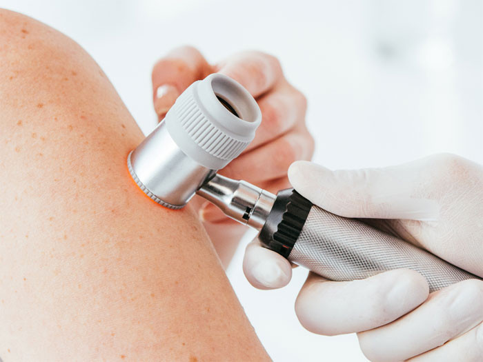 Alt text: A close-up of a syringe injecting dermal filler into a woman's face.