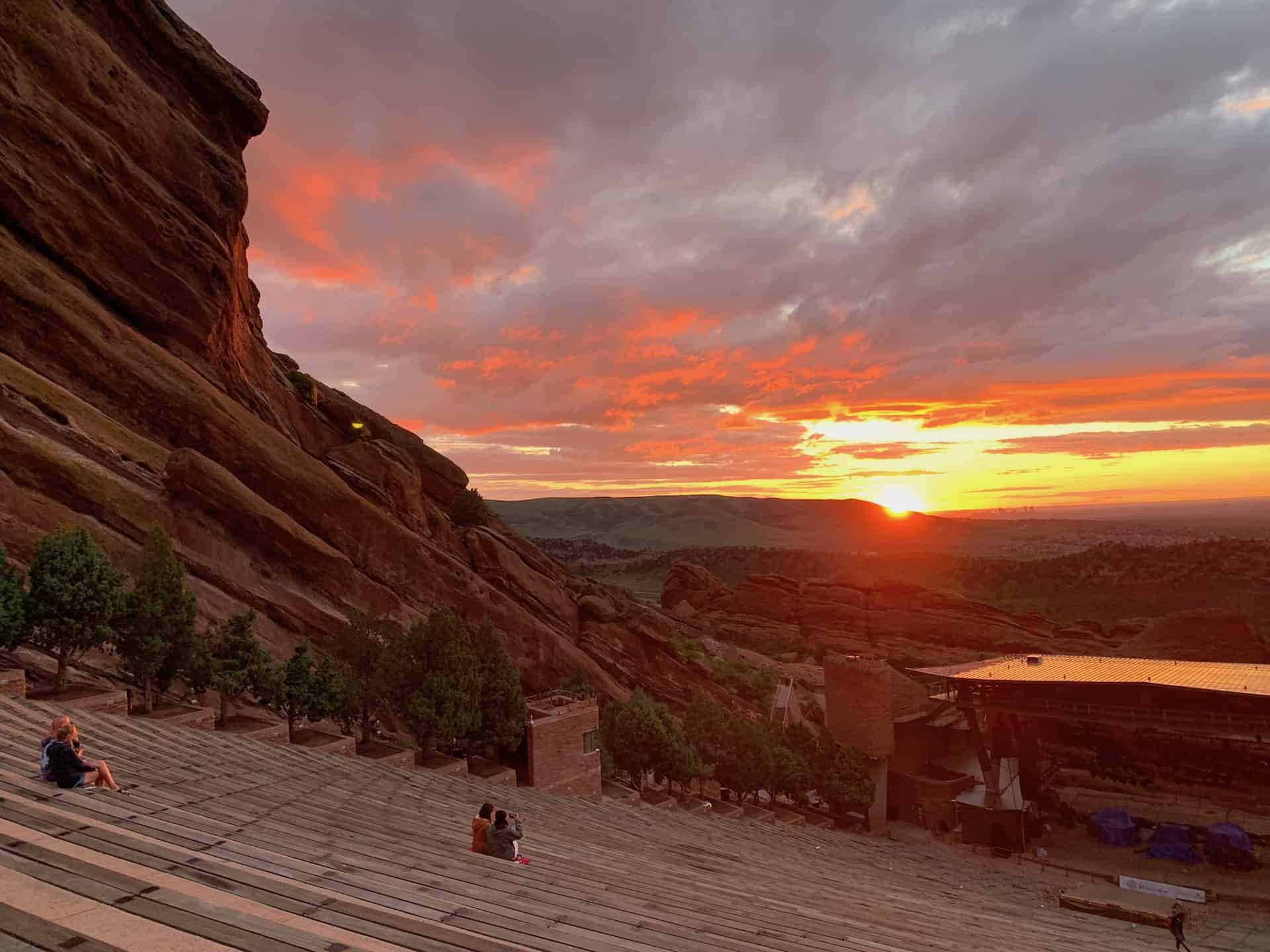 Vibrant sunrise colors illuminating the Red Rocks Amphitheatre in Denver