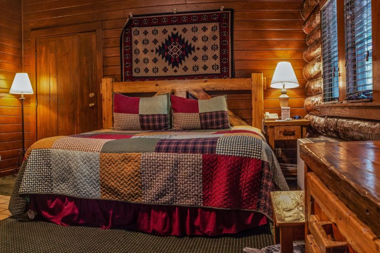 Cozy interior view of a Sunset Cabin King room featuring a wood-burning fireplace