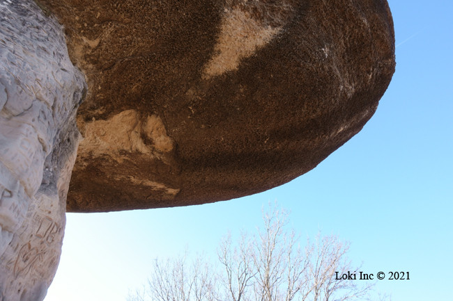 The underside of a mushroom rock formation, showcasing geological layers