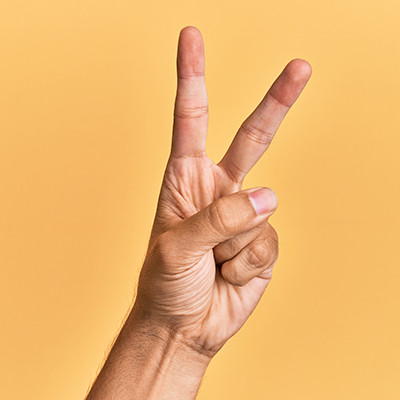 Man making the horns gesture, potentially offensive in some cultures.