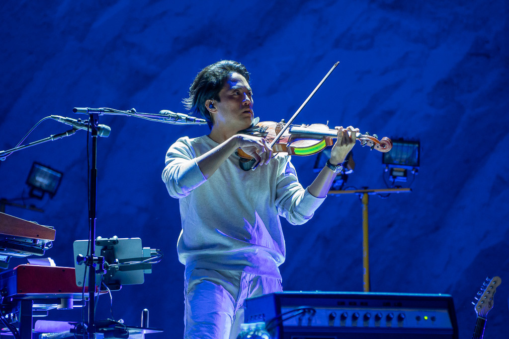 Vampire Weekend performing a song with psychedelic lighting at Red Rocks Amphitheatre during their set.