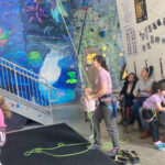 Rock climber being belayed indoors for safety