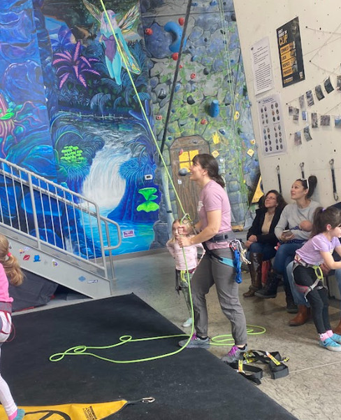 Rock climber being belayed indoors for safety